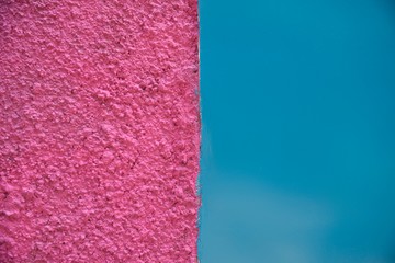 Bright vivid rough textured pink and smooth blue color divided wall