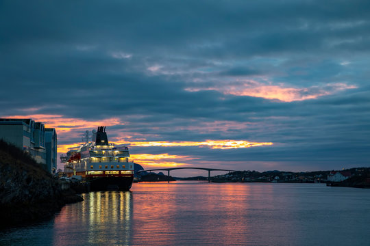Passenger ship at quay in Bronnoysund with colorful clouds, Nordland county