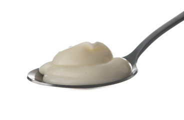 Sour cream in spoon isolated on white background