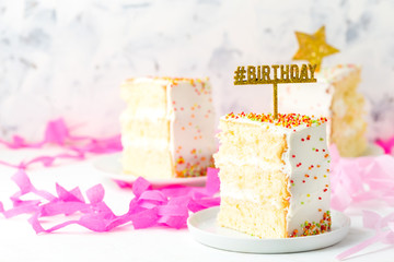 Slice of birthday cake and pink paper decoration, copy space
