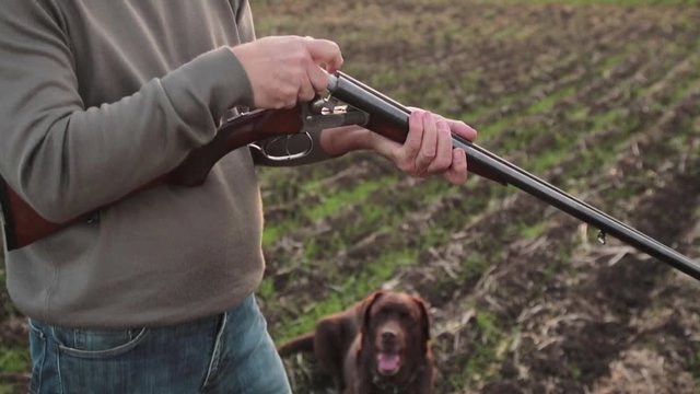 The man hunter charging the double-barreled shotgun with cartridges. 16 gauge
