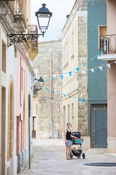 Presicce, Apulia - A woman wheeling her stroller through the old town