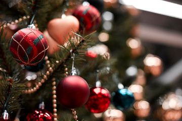 Red bauble hanging from a decorated  tree