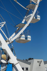 Giant ferris wheel with chairs, metallic structure, recreational element near the river