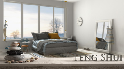 Wooden vintage table shelf with pebble balance and 3d letters making the word feng shui over blurred modern colored bedroom with big panoramic window, zen concept interior design