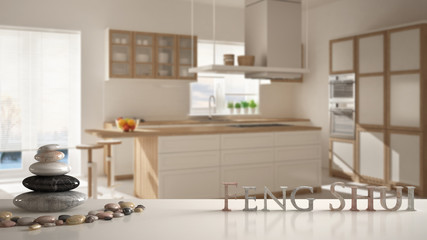 White table shelf with pebble balance and 3d letters making the word feng shui over wooden and white kitchen with island, stools and windows, zen concept interior design