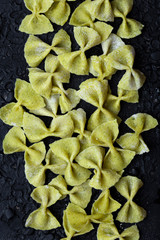 raw homemade pasta Farfalle of broccoli on a black background