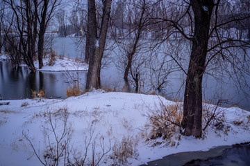 picturesque view of first snow on Ontario lake with dramatic sky, Canada
