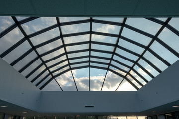 Modern glass roof with steel grid frames. Skylight rooftop window with symmetrical grid steel beams. Architectural detail and design on glass rooftop