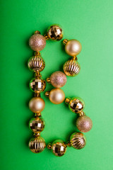 Letter B made of Christmas toys on green background. ABC