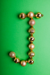 Letter J made of Christmas toys on green background. ABC