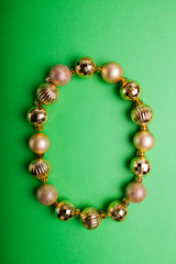 Obraz premium Letter O made of Christmas toys on green background. ABC