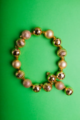 Letter Q made of Christmas toys on green background. ABC