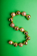 Letter S made of Christmas toys on green background. ABC