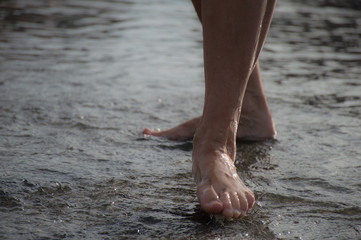 Wet feet standing in water from a caucasian female