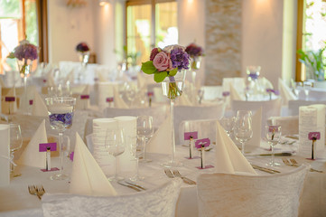 Beautifully decorated in white colours wedding hall with purple flowers