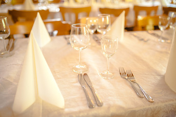 Restaurant table served with white tablecloth, wineglasses ready for guests