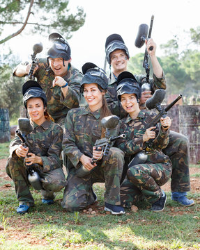 Portrait of paintball players wearing uniform and holding guns ready for playing outdoor