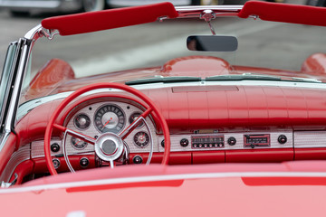 Close up of vintage red car driver's wheel and dashboard
