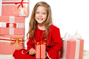 Happy smiling girl holding a gift in a red and white paper with red bow isolated on a white background. Girl with gift box. Merry Christmas. Shopping. Black Friday. Discount 