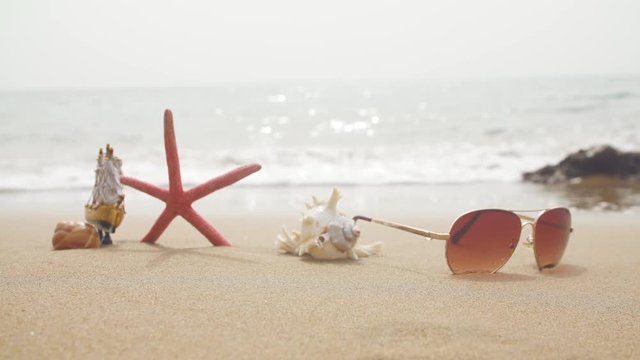 background sunglasses and starfish on the beach sand
