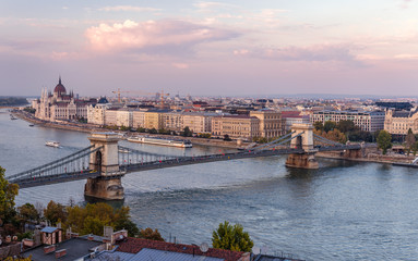 Panoramic view of the Chain Bridge that spans river Danube in Budapest, Hungary, in the dusk. The Hungarian Parliament is in the background. Photo from the Buda Castle.