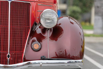 Close up of vintage burgundy car bumber and lamps