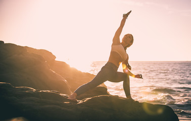 Woman making yoga poses in Baker beach, San francisco