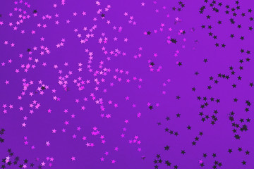 Beautiful festive ultra violet background with metallic star shaped confetti. Holiday or decoration concept.