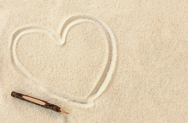 Fototapeta na wymiar Heart shape on the sand beach and a pencil, write your own story concept