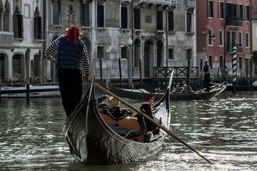Fototapeta na wymiar Venice, Italy - 2/21/2016. gondolier carries tourists by gondola, in canal Grande