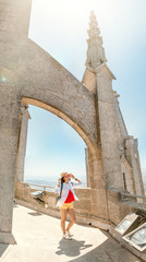 Fototapeta na wymiar Tourist traveler girl on mount Tibidabo look at the Church of Sacred Heart in Barcelona