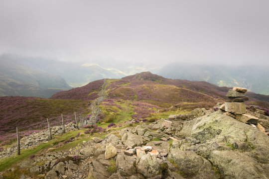 A the top of Great Langdale with the heathered mountains covered in the clouds England