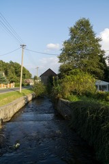 Water stream in the small village in nature. Czech Republic