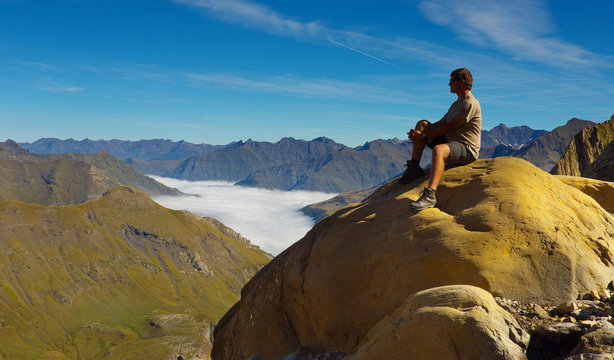 Resting tourist on the stone with mountains on backround, Pyrenees