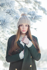 Beautiful winter portrait of young woman in the snowy scenery