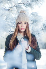 Beautiful winter portrait of young woman in the snowy scenery