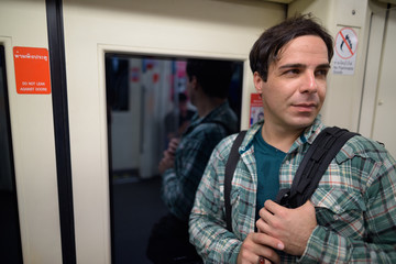 Handsome Persian tourist man inside the subway train