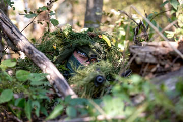 special forces, soldier assault rifle with silencer, optical sight. behind cover waiting in ambush