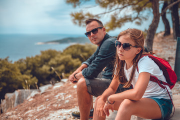 Father and daughter sitting on a rock after hiking