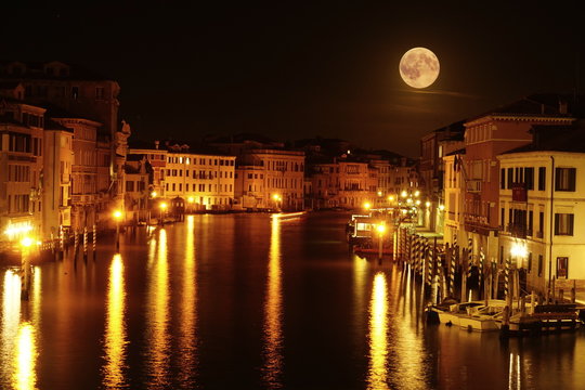 Long exposure photograph of Grand Canal by night with stunning full moon  view. Venice, Italy
