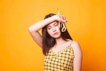 Unhappy young Asian woman with measuring tape.