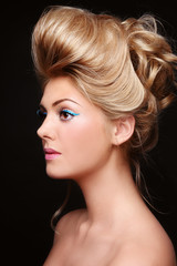 Fototapeta premium Young beautiful woman with fancy cat eye make-up and vintage style prom hairdo