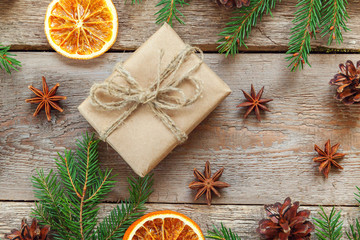 Christmas New Year composition with gift box fir branch pine cones orange slices on old shabby rustic wooden background Xmas holiday december decoration. Flat lay top view Time for celebration concept