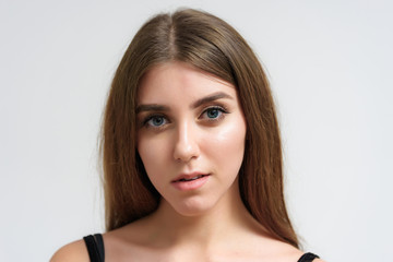 Studio portrait of a smiling happy beautiful brunette girl on white background.