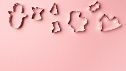 Christmas cookies various shape cutter on pink background with copy space. Top view. Flat lay. Trendy colorful photo. Minimal style with colorful paper backdrop. Christmas concept.