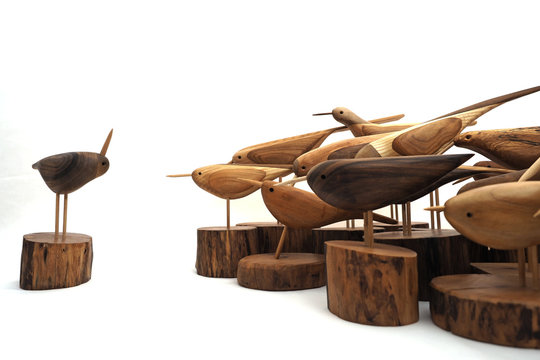 a group of wooden birds on a white background, manual work, with conductor.