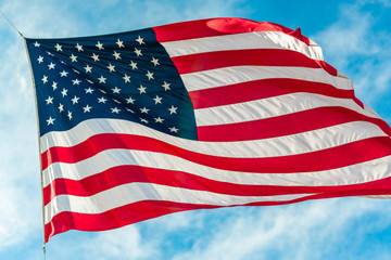 American flag waving in blue cloudy sky