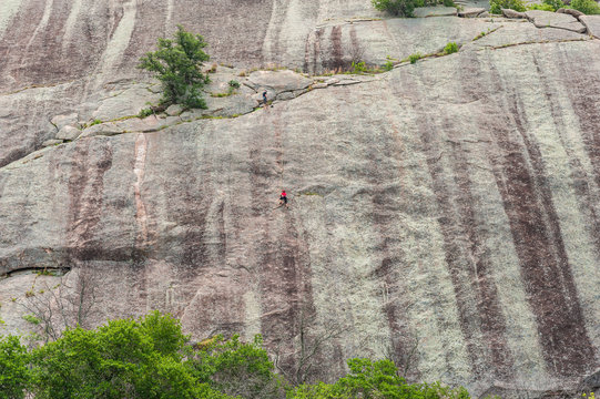 Climbers ascends a granite rock boulder in the Texas Hill Country