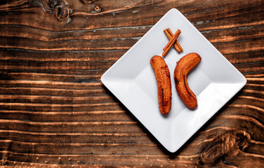 fried banana served on white square plate over dark wood